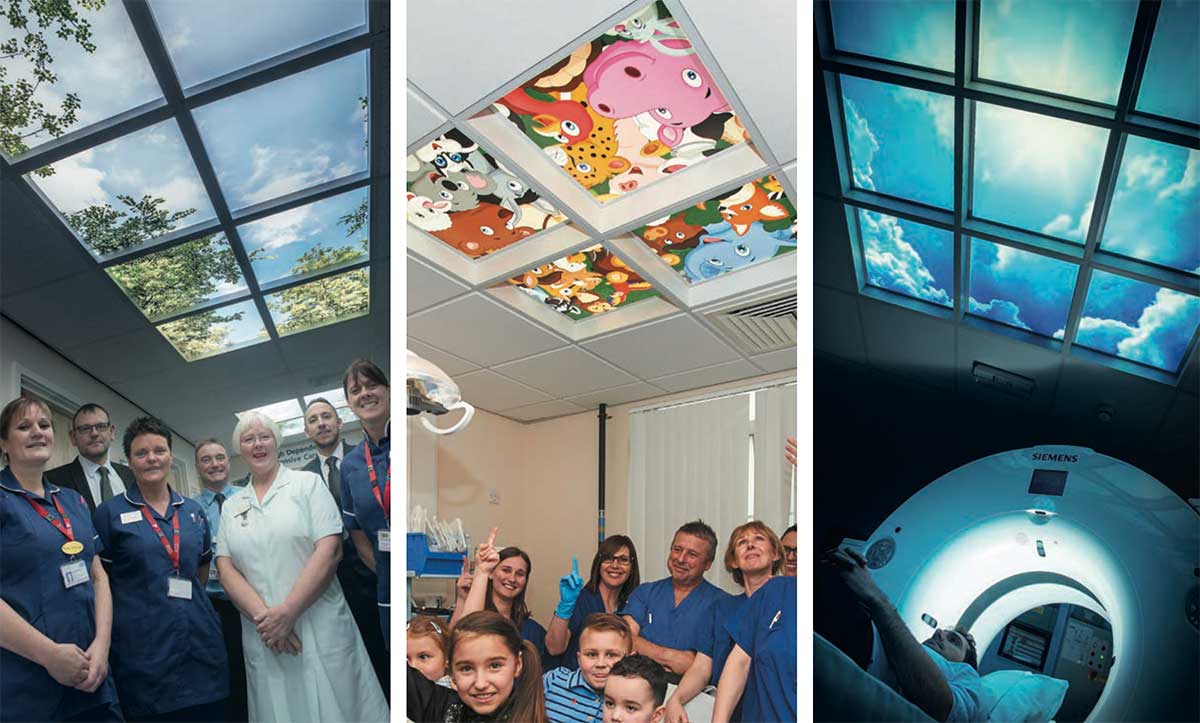 LED sky panels displaying clear blue sky & greenery, with NHS staff stood below looking pleased. Children & NHS staff smiling and pointing at LED ceiling lights which display colourful cartoon characters. LED sky panel showing vivid, relaxing images of a blue sky with white clouds & sunlight within a hospital CT scan room.
